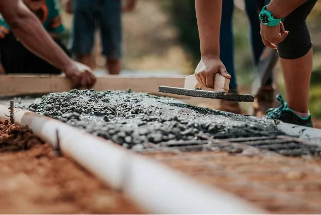 Concrete pavement work during building project.webp